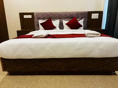 a bedroom with a large bed with red pillows at Surabhi Comforts Inn in Mysore