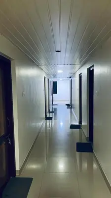 an empty hallway in a building with a long corridor at Saravana tourist home in Kozhikode