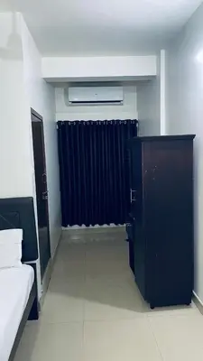 a room with a bed and a black curtain at Saravana tourist home in Kozhikode
