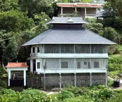 an old house with a roof on top of it at Silver Rock Cottage Valparai in Vālpārai