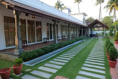 a courtyard of a building with grass and plants at Breakwater Palace in Cochin