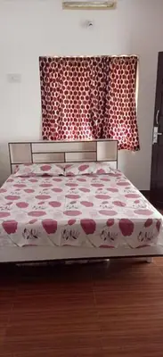 a bedroom with a bed with a red and white comforter at Garden Beach in Cochin