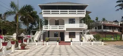 a white house with a white fence in front of it at Garden Beach in Cochin