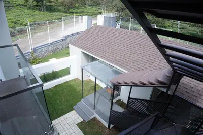 a balcony with a chair and a glass table at Jacaranda Home Stay in Kotagiri
