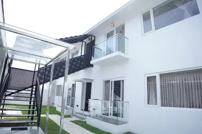 an external view of a white building with a staircase at Jacaranda Home Stay in Kotagiri