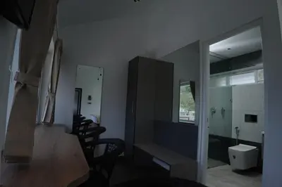 a room with a table and chairs and a mirror at Jacaranda Home Stay in Kotagiri