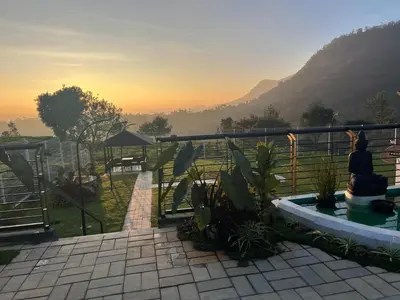 a person standing on a balcony looking at the mountains at Jacaranda Home Stay in Kotagiri