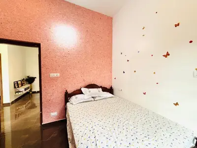 a bedroom with a bed and a wall with butterflies at Tanis serenity in Meenangadi
