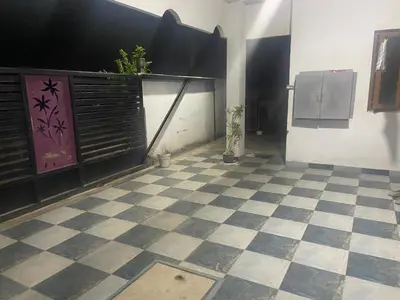 a room with a cat standing on a checkered floor at PK Homestay in Coimbatore