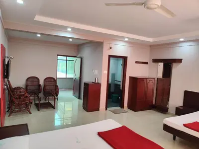 a living room with a couch and a table and chairs at Chandragiri INN in Kalpetta