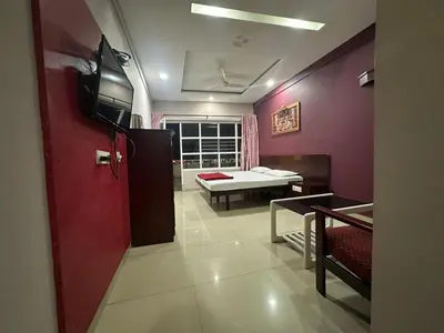 a room with purple walls and a room with a table at Chandragiri INN in Kalpetta
