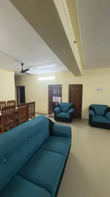 a living room with a blue couch and chairs at Roshan's Welcome Home Stay in Mysore