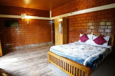 a bedroom with a bed in a brick wall at Stay with Lakeview Ponnampet in Ponnampet