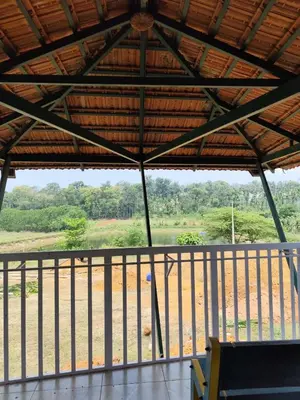 a view of a field from the porch of a building at Stay with Lakeview Ponnampet in Ponnampet