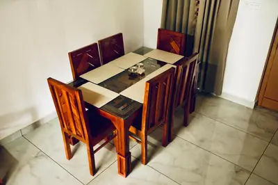 a dining room table and chairs in a room at 50 Fables Vintage Kerala Pool Home in Pulpally