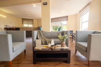 a living room with two couches and a coffee table at SaffronStays Valleyfall in Kotagiri