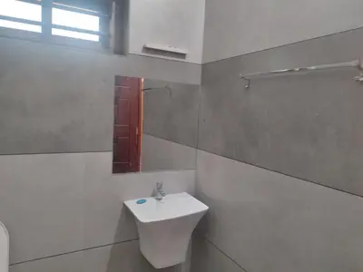 a white bathroom with a sink and a mirror at AANMEEZ Homestay in Kuthuparamba