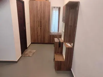 an empty hallway with a door and a window at AANMEEZ Homestay in Kuthuparamba