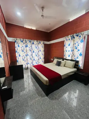 a bedroom with a large bed with red and blue curtains at Spillway private pool villa in Meenangadi