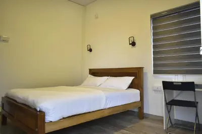 a bedroom with a bed with white sheets and a window at Rays Of Bliss Boutique Resort in Mananthavady