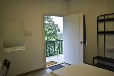 a bedroom with a door open to a balcony at Rays Of Bliss Boutique Resort in Mananthavady