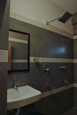 a bathroom with a sink and a mirror at Vista Chembra Service Apartment 20A in Meppādi