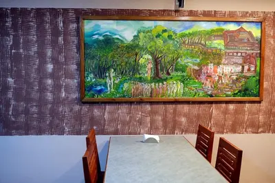 a painting on the wall of a room with a table at Vista Chembra Service Apartment 20A in Meppādi