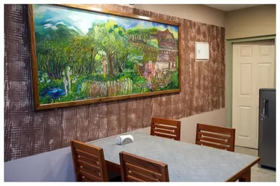 a painting on a wall with a table and chairs at Vista Chembra Service Apartment 20A in Meppādi