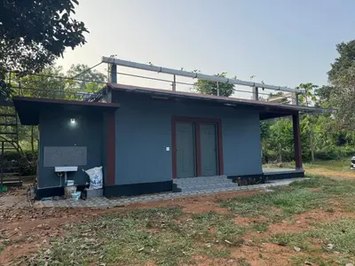 a small blue house with a roof at Spice garden farm stay in Kodali