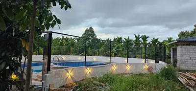 a fence around a swimming pool in a yard at Ambience Retreat in Sivasamudram