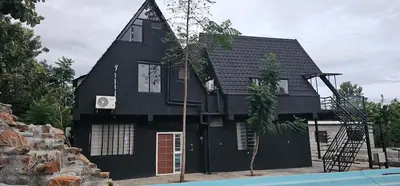 a black house with a pool in front of it at Ambience Retreat in Sivasamudram