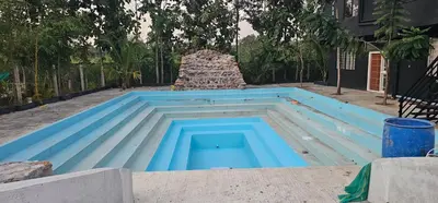 a swimming pool with a pile of bricks in a yard at Ambience Retreat in Sivasamudram