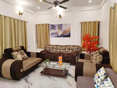 a living room with two couches and a table at shalom 3bhk in Mysore
