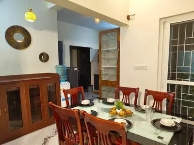 a dining room with a table and some chairs at shalom 3bhk in Mysore