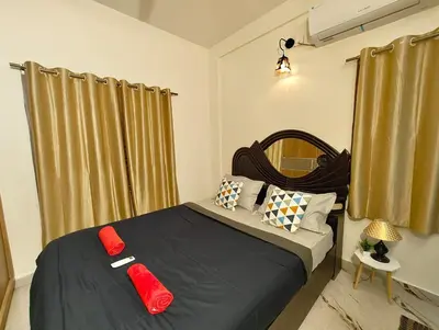 a bedroom with a bed with red pillows on it at shalom 3bhk in Mysore