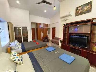 a living room with two beds and a flat screen tv at shalom 3bhk in Mysore