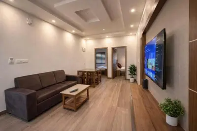 a living room with a couch and a flat screen tv at Honeymoon Holidays in Vythiri
