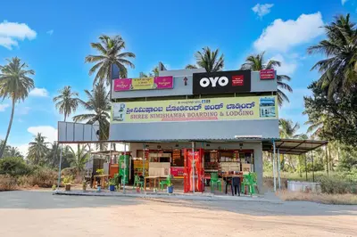a store with chairs and tables in front of it at Hotel O Nimishamba Residency in Mysore