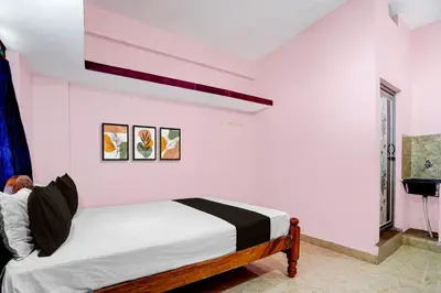 a bedroom with a bed in a room at Hotel O Nimishamba Residency in Mysore