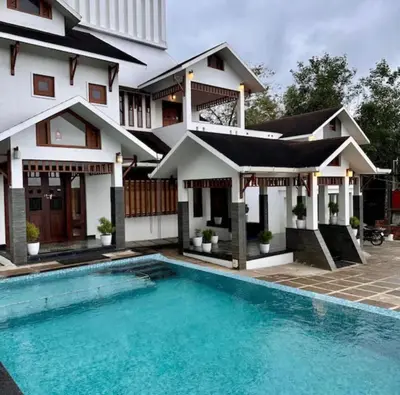a house with a swimming pool in front of it at Petrus Signature Villa in Sultan Bathery