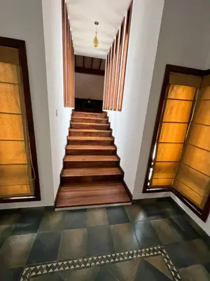 a staircase in a building with wooden floors and windows at Petrus Signature Villa in Sultan Bathery
