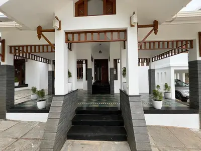 a house with a staircase leading to the front door at Petrus Signature Villa in Sultan Bathery