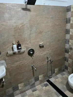 a bathroom with a shower with a sink and a toilet at Petrus Signature Villa in Sultan Bathery