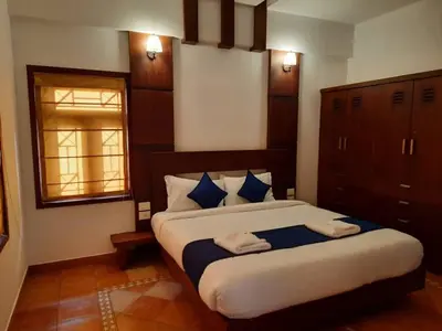 a bedroom with a large bed with two towels on it at Petrus Signature Villa in Sultan Bathery