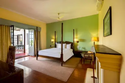 a bedroom with a bed and a balcony at amã Stays & Trails - Cottabetta Bungalow, Coorg in Gonikoppal