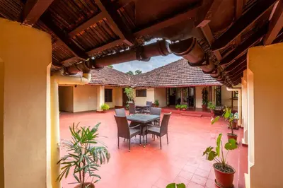 an outdoor patio with a table and chairs at amã Stays & Trails - Cottabetta Bungalow, Coorg in Gonikoppal