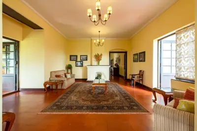 a living room with yellow walls and a fireplace at amã Stays & Trails - Cottabetta Bungalow, Coorg in Gonikoppal