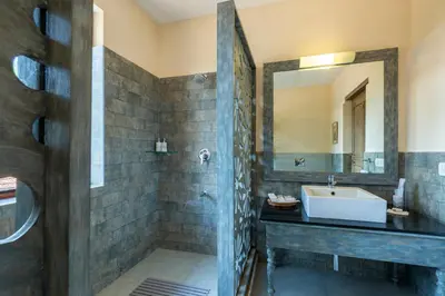 a bathroom with a sink and a mirror at amã Stays & Trails - Taneerhulla Bungalow, Coorg in Titimati