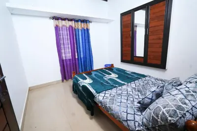 a bedroom with a bed and a mirror and a window at Stay Vista in Mananthavady