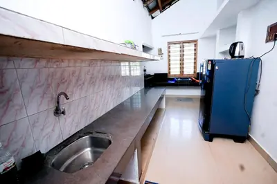 a kitchen with a sink and a blue refrigerator at Stay Vista in Mananthavady